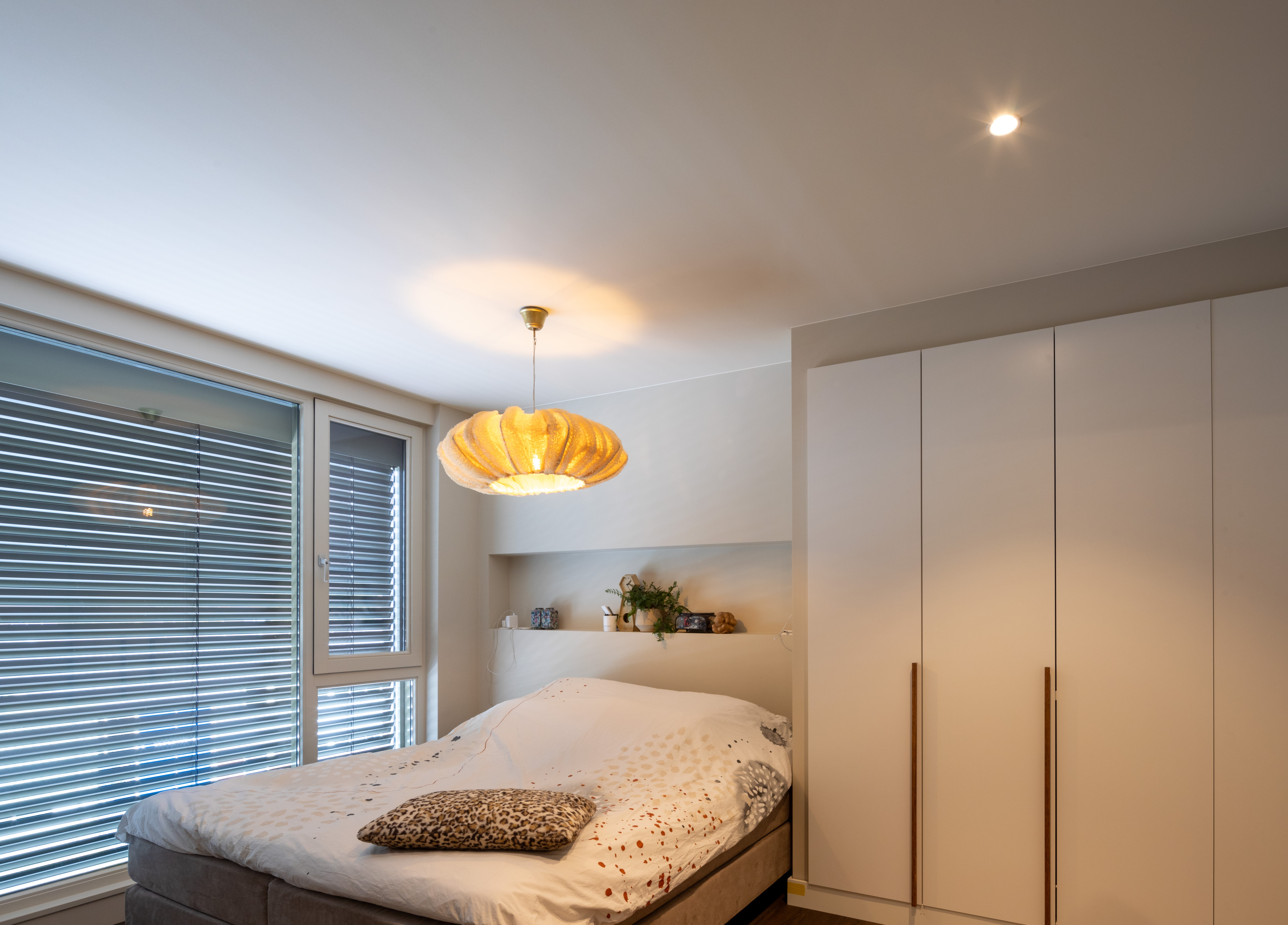 Slaapkamer met spanplafond en verlichting